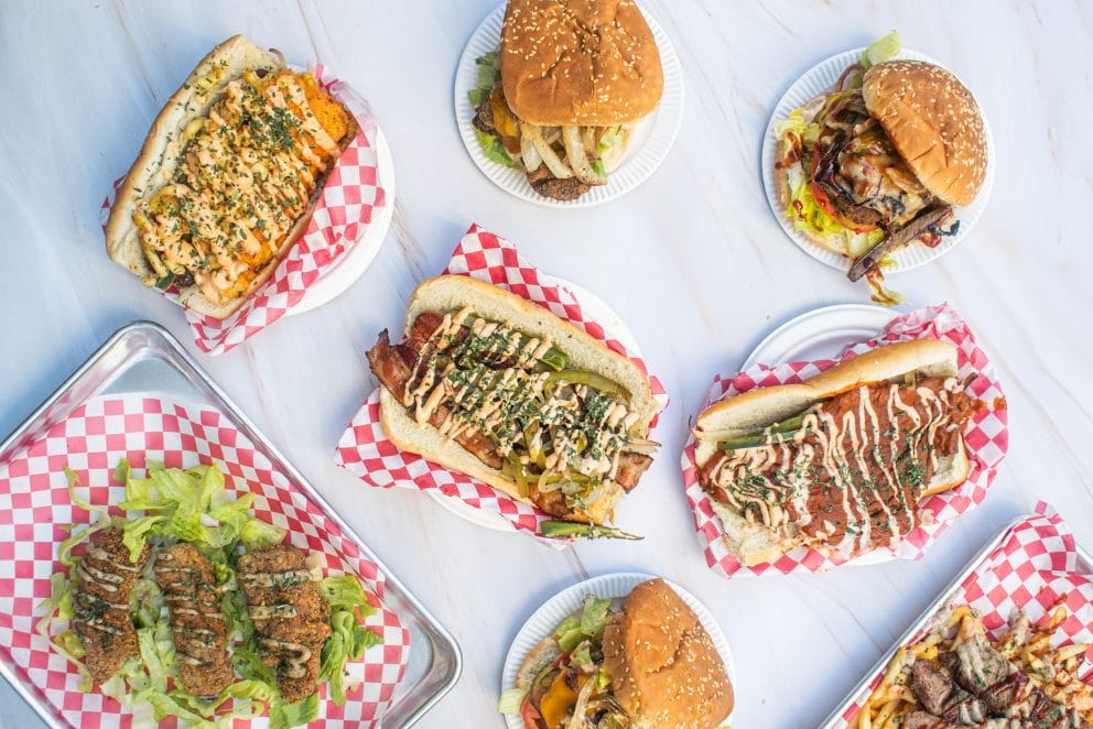 A spread of loaded Winky Dinky Dogs on checkered paper