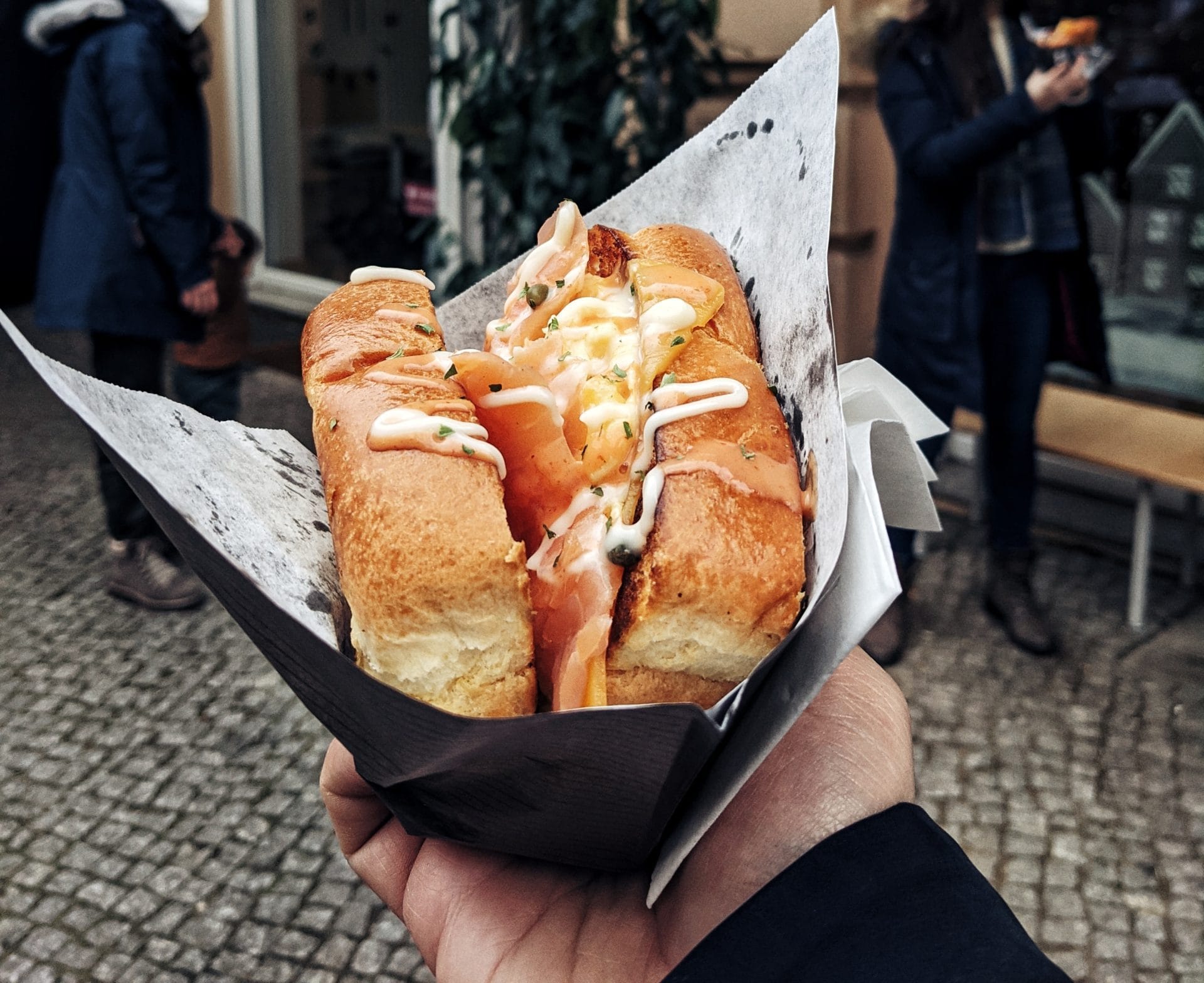 Loaded hot dog held up on the street